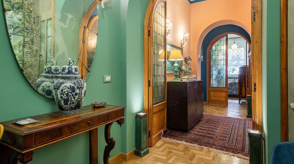 um corredor com um espelho e um vaso sobre uma mesa em Maison et studio l'Orangerie em Roma