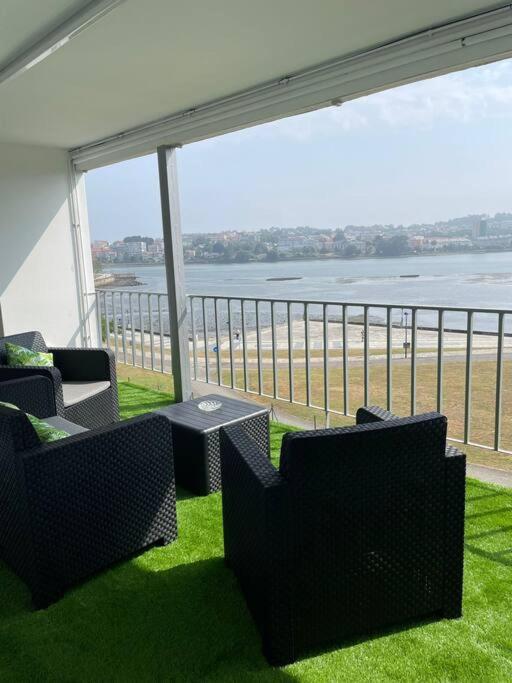 Un balcón con sillas y vistas al océano. en Vibes Coruña-Paz 16, en Culleredo