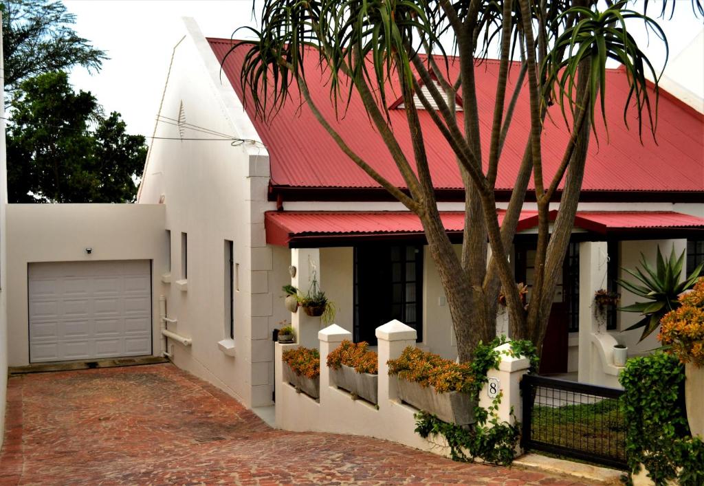 une maison avec un toit rouge et un arbre dans l'établissement Zebra Cottage - House - Backup Power - Fast WIFI, à Pretoria