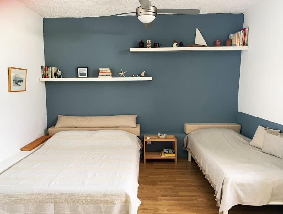 Duas camas num quarto com paredes azuis em Cosy studio overlooking Porto Germeno gulf em Aigósthena