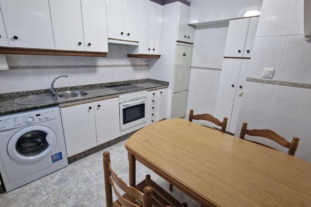 eine Küche mit einem Tisch und einer Waschmaschine in der Unterkunft VibesCoruña- San Rosendo 25 in A Coruña