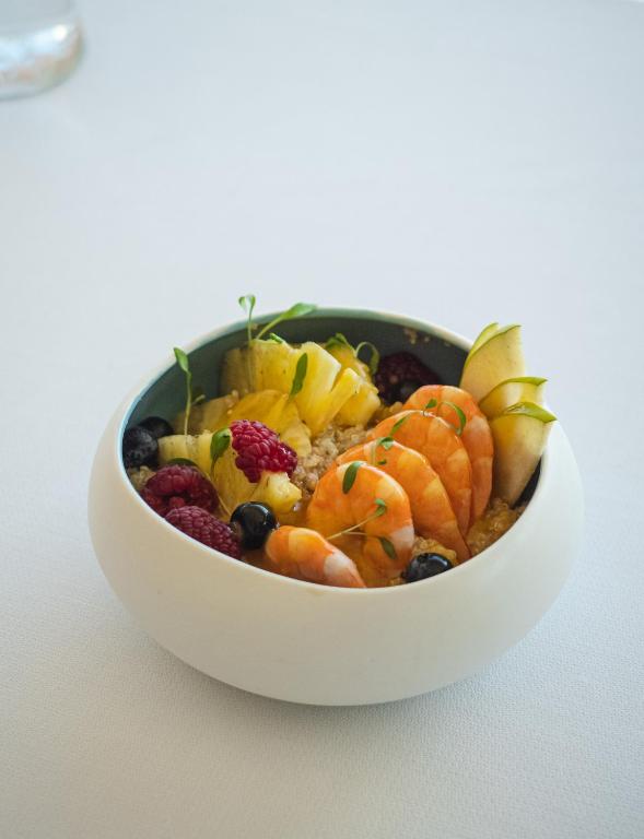 a white bowl filled with fruit on a table at Hotel Baia in Cascais