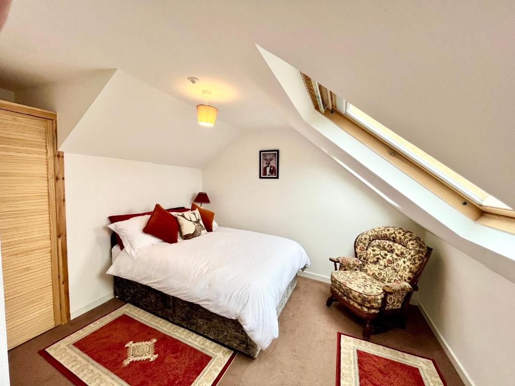 a bedroom with a bed and a chair in a attic at Apartment in Coldstream in Coldstream