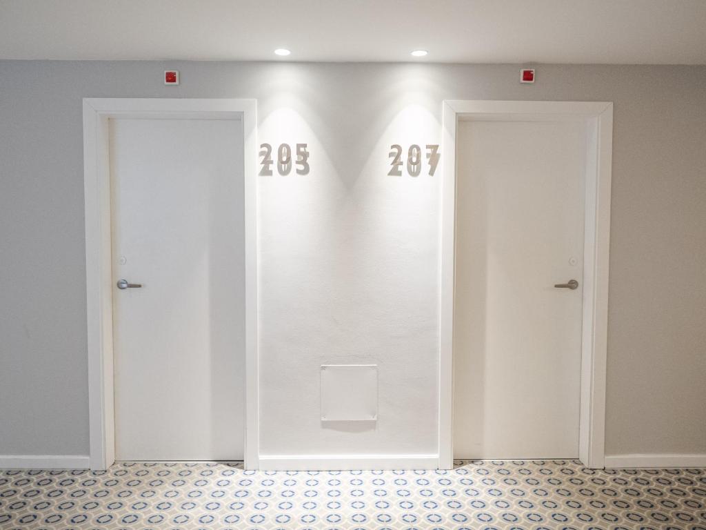 two doors in a room with numbers on the wall at Hotel Baia in Cascais