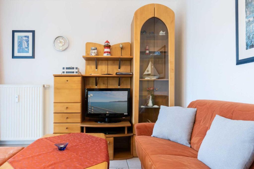 ein Wohnzimmer mit einem Sofa und einem TV in der Unterkunft Haus Roland Wohnung 27 in Zinnowitz