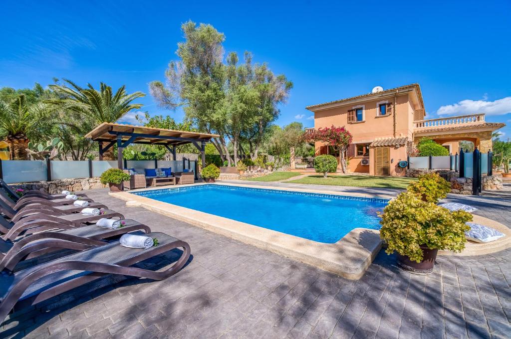 uma villa com uma piscina e espreguiçadeiras em Ideal Property Mallorca - Son Morei Gran em Muro