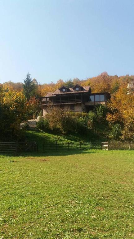 a house sitting on top of a lush green field at Planinska kuća HIL - Bjelašnica in Sarajevo