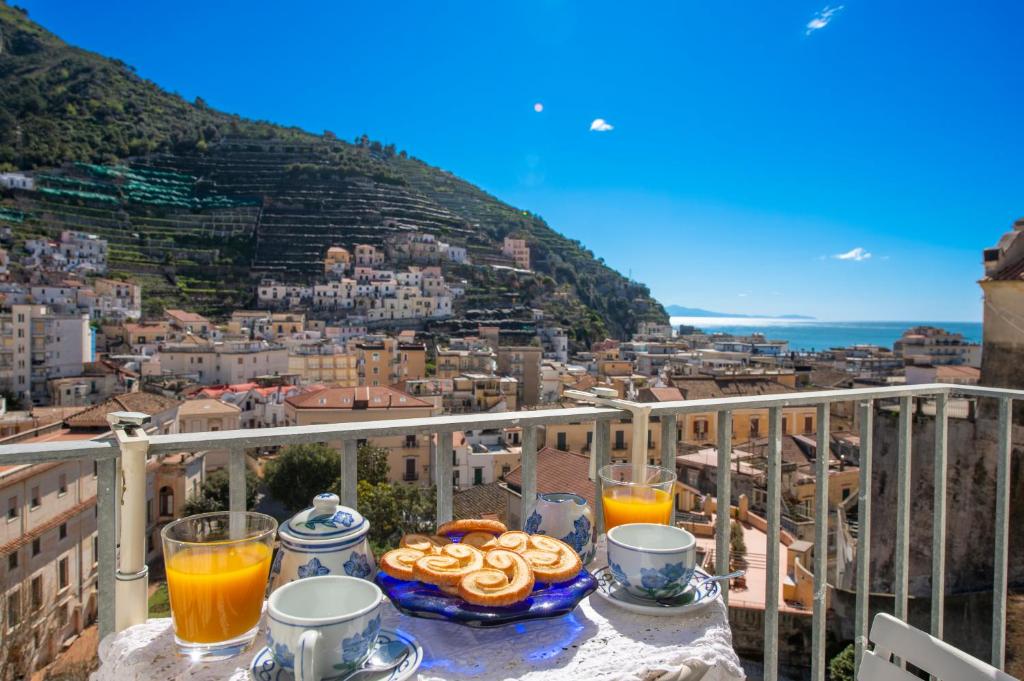 una mesa con comida y bebida en la parte superior de un balcón en Casa Diodora, Costiera Amalfitana, en Maiori