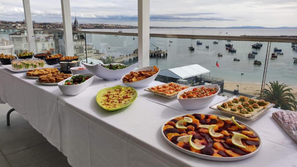 a buffet with many different types of food on a table at Hotel Baia in Cascais