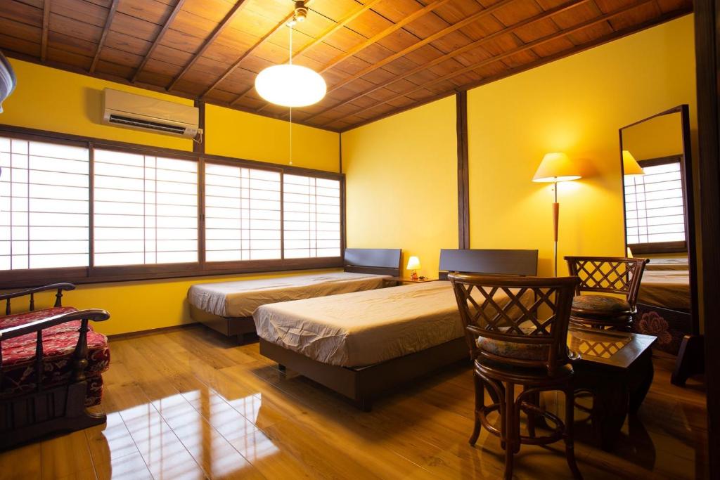 sypialnia z 2 łóżkami, biurkiem i krzesłem w obiekcie Chikugo Yoshii Guest House IKUHA - Vacation STAY 00077v w mieście Ukiha