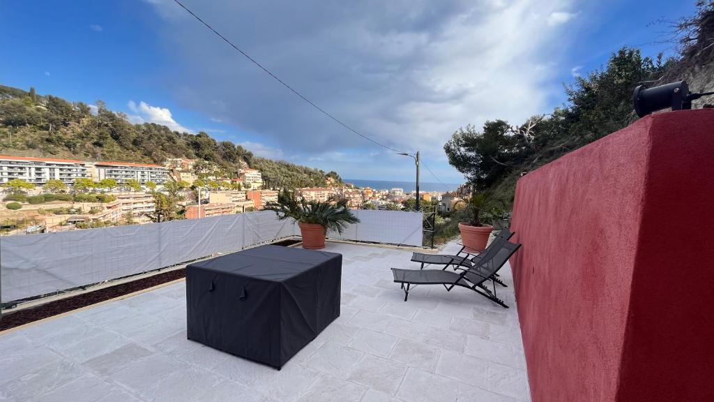 eine Terrasse mit zwei Bänken und einem Tisch auf dem Dach in der Unterkunft le cabanon in Roquebrune-Cap-Martin