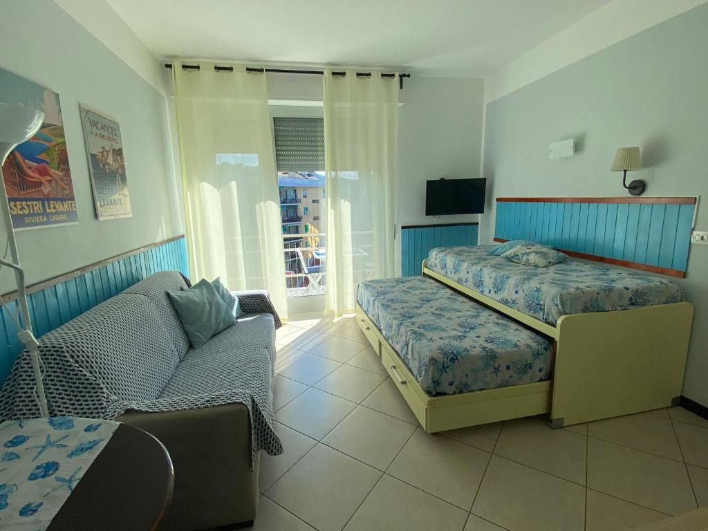 - une chambre avec un lit et un canapé dans l'établissement Appartamenti Azzurro Smeraldo, à Sestri Levante