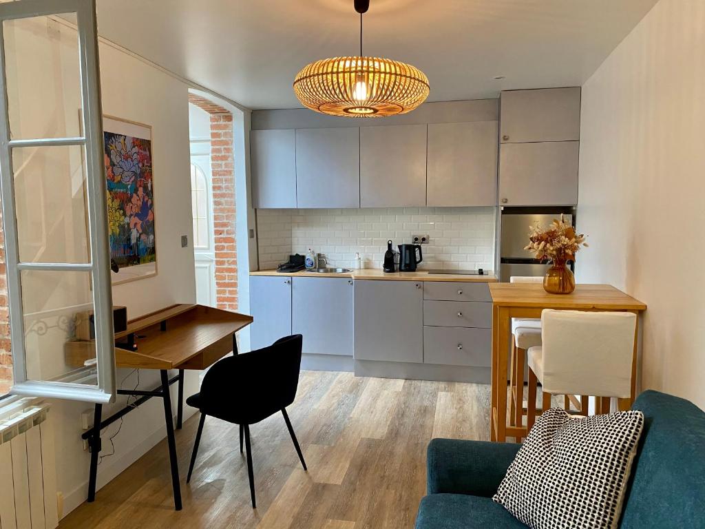 a kitchen with a table and a dining room at P&#39;tite maison du Parc in Orléans