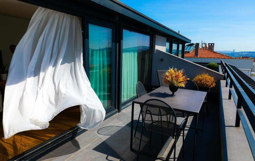 eine Terrasse mit einem Tisch und Stühlen auf dem Balkon in der Unterkunft Ando Living - Taksim Gumussuyu Townhouse in Istanbul