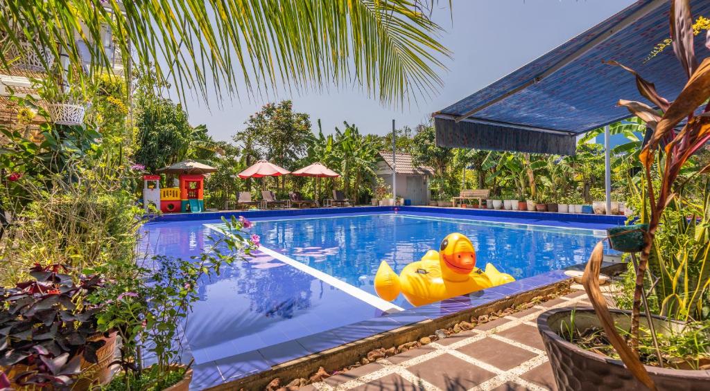 una piscina con un pato de goma en el medio en Sanssouci Kep en Kep