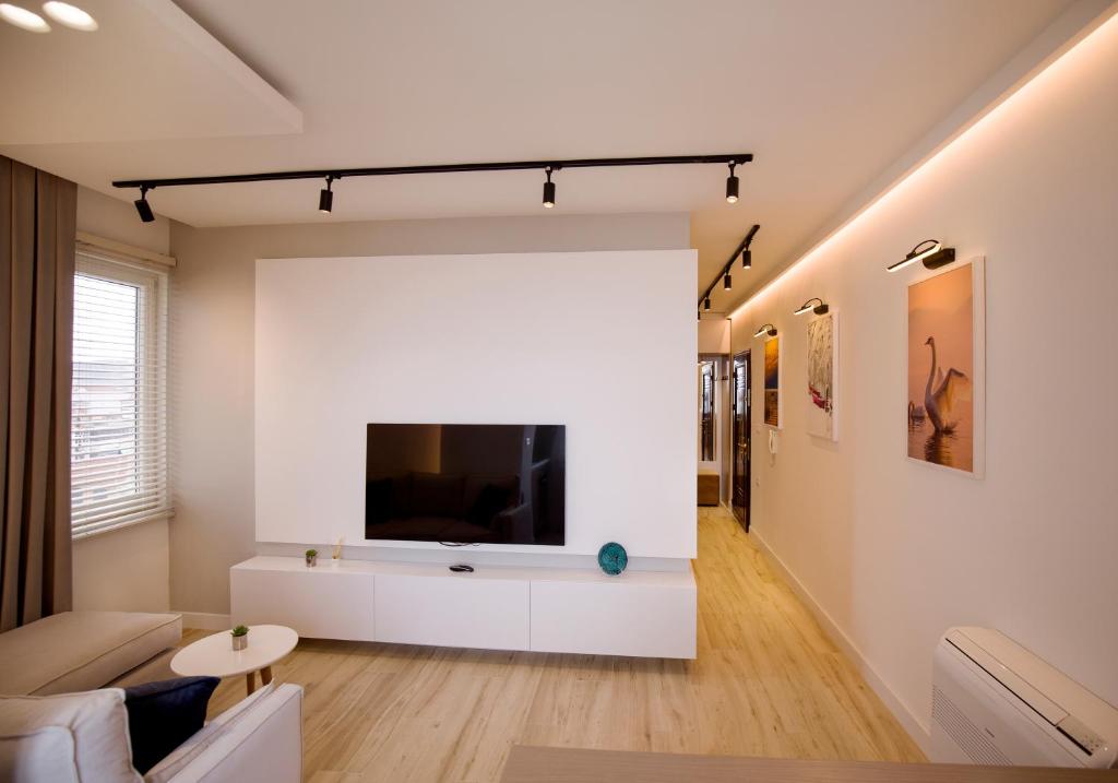 een woonkamer met een grote flatscreen-tv aan de muur bij Tola Apartaments in Pogradec