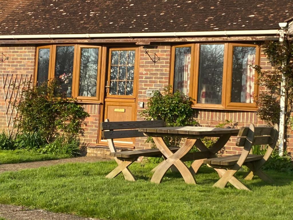 a picnic table in the grass in front of a house at Arbor Cottage in Eastbourne