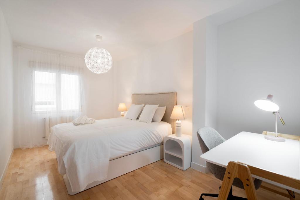 Habitación blanca con cama blanca y escritorio. en For You Rentals Central Apartment Atocha Station Madrid TEL3 en Madrid