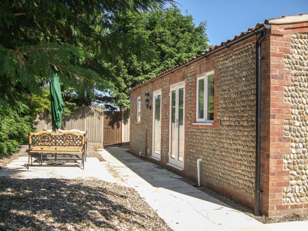 ノリッジにあるThe Old Barnの煉瓦造りの建物の横に座るベンチ