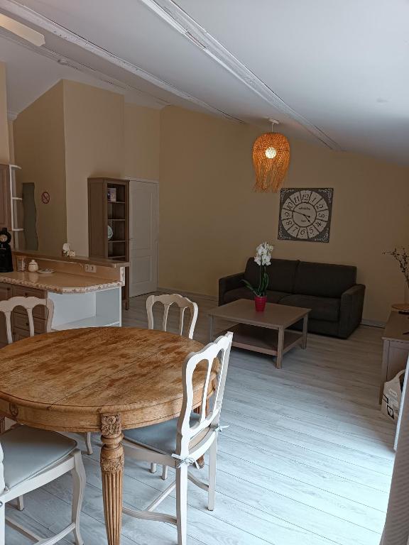 a living room with a table and a couch at Aux Berges du Canal in Capestang