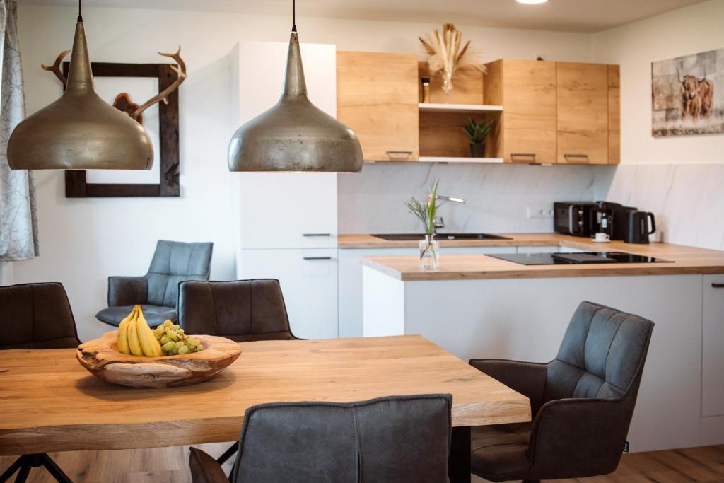 una cocina con una mesa de madera y un bol de fruta. en Hoamhaus, en St. Wolfgang