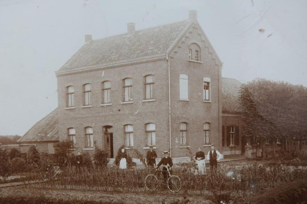 Un groupe de personnes debout devant une grande maison dans l'établissement Das Herrenhaus, à Kevelaer