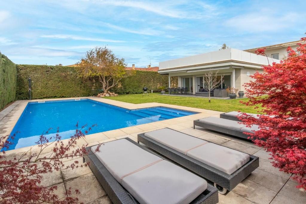 un patio trasero con piscina y una casa en Marisan, en Vall-Llobrega