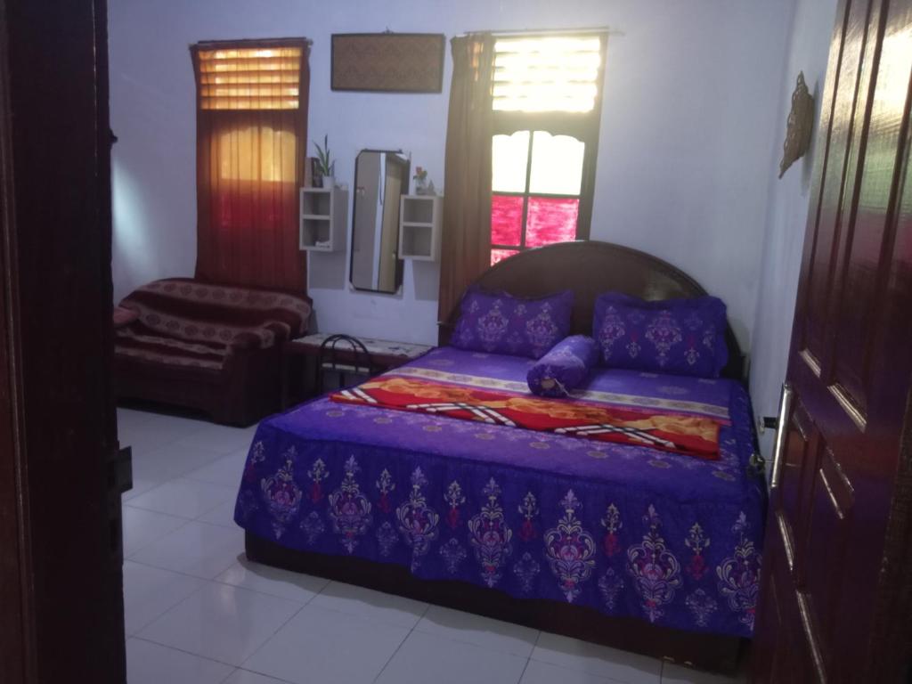 1 dormitorio con 1 cama y 1 silla en ORANGUTAN TREKKING LODGE Jungle Tour Only Book with Us, en Bukit Lawang