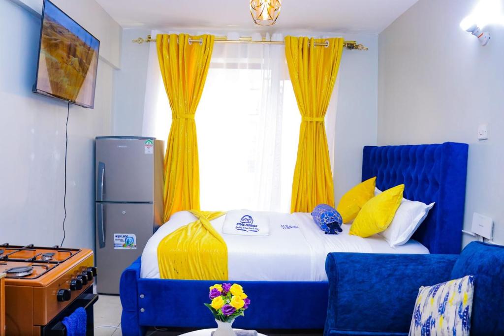 1 dormitorio con 1 cama con cortinas azules y amarillas en Enac Homes - Classy, Elegant Executive Studios - Kiambu Road en Kiambu