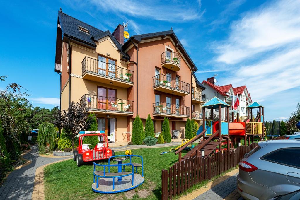a house with a playground in front of it at NEMO 2 in Karwia