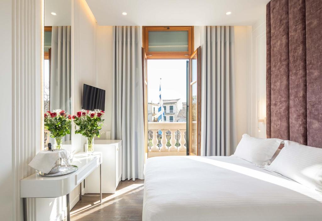 a bedroom with a white bed and a window at Bella Venezia in Corfu