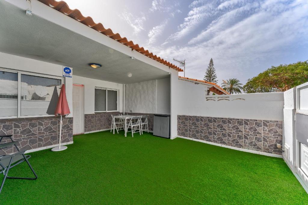 ein Haus mit grünem Rasen im Hinterhof in der Unterkunft Cozy apartment in Costa del Silencio in Costa Del Silencio