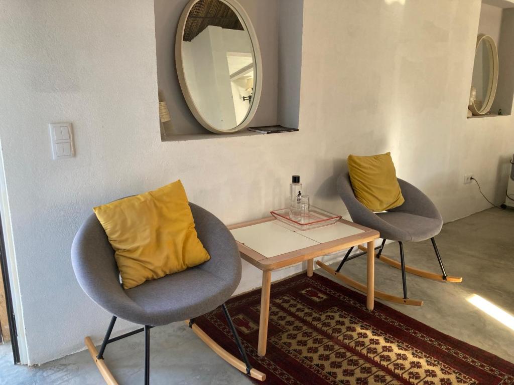 una stanza con due sedie, un tavolo e uno specchio di Yoga Farm a Tavira