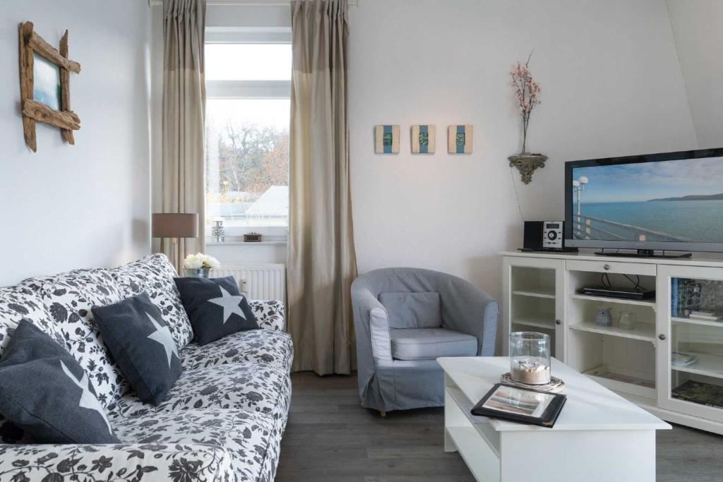 een woonkamer met een bank en een tv bij Villa Marin Wohnung 25 in Zinnowitz