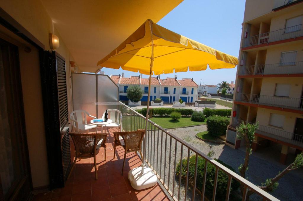 a balcony with a table and a yellow umbrella at Mare Nostrum 223 in Torroella de Montgrí