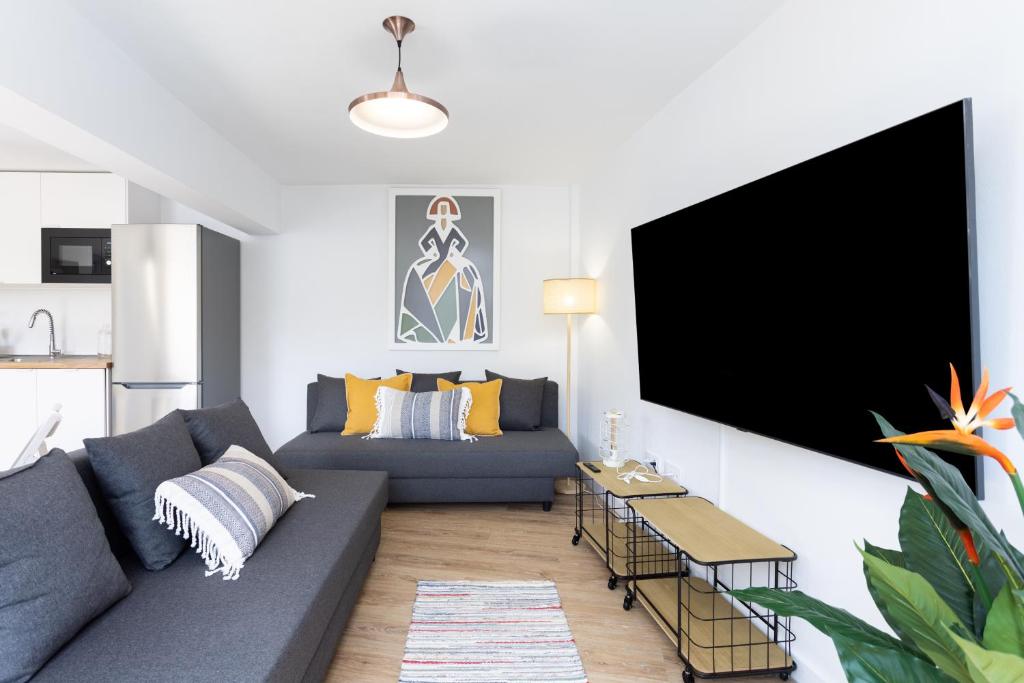 a living room with a couch and a flat screen tv at 150 Chill and sun Alcala By Sunkeyrents in Alcalá