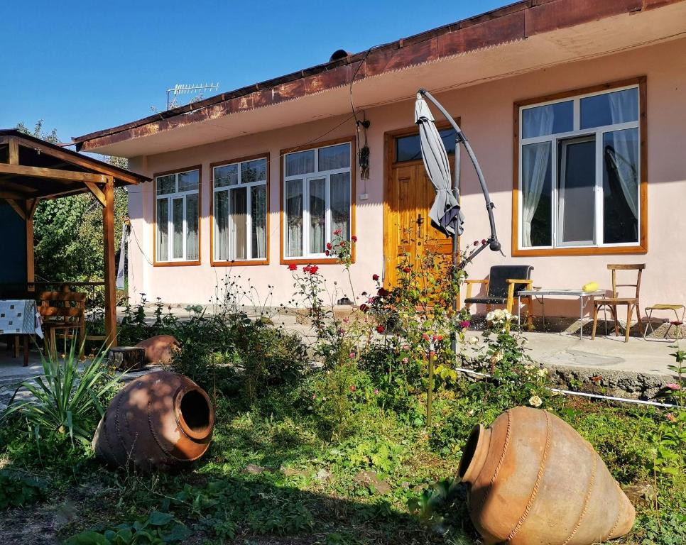 a house with two large vases in front of it at Tatev Guest House in Tatʼev