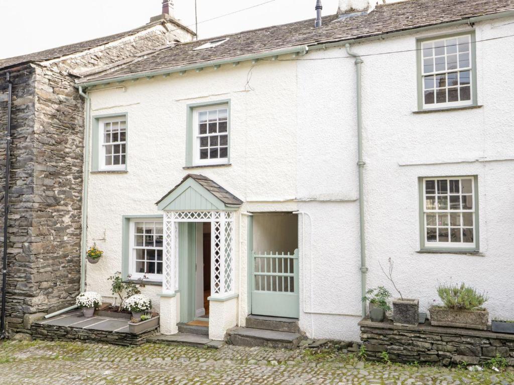 a white house with a blue door at Jessamine Cottage in Ambleside