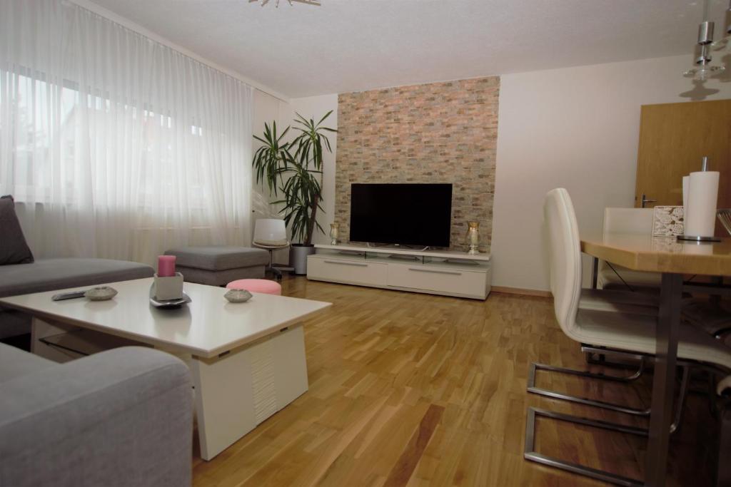 un soggiorno con divano, TV e tavolo di Luxury Apartment in Stuttgart a Stoccarda