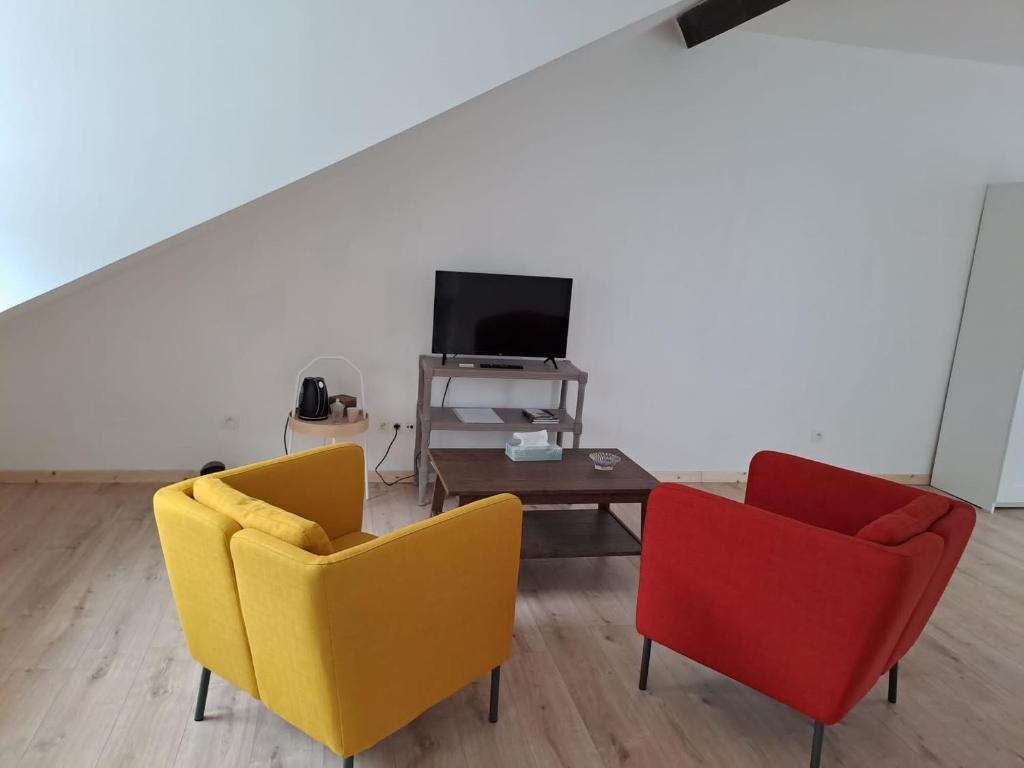 twee stoelen en een tafel in een woonkamer met een tv bij Citabelle For 3 in Dinant