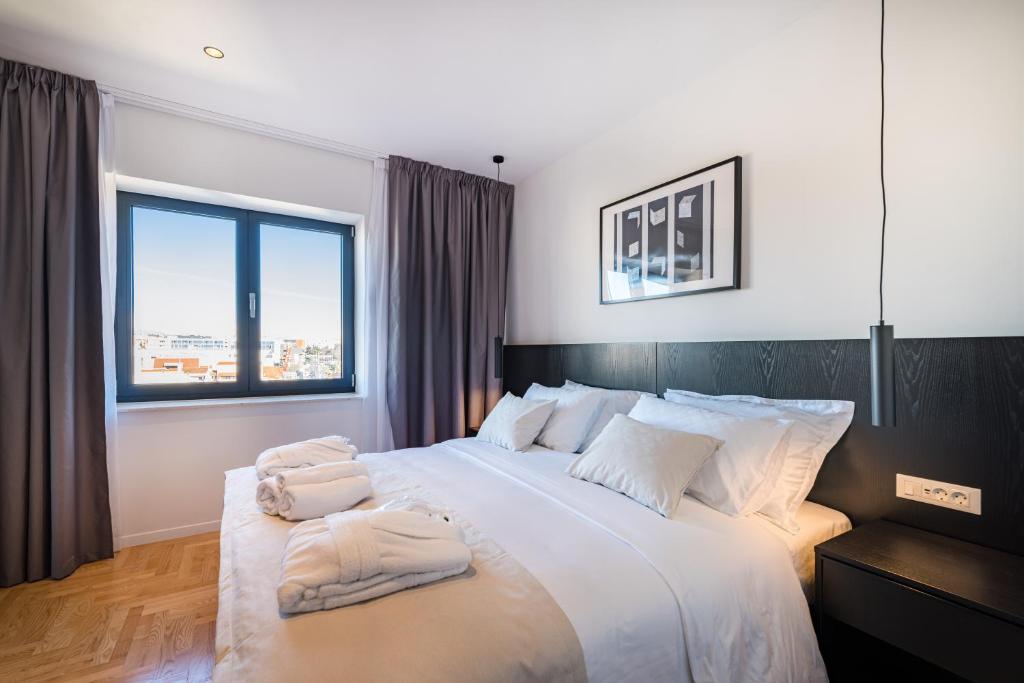 a bedroom with a large bed with two towels on it at Miramare Hotel in Zadar