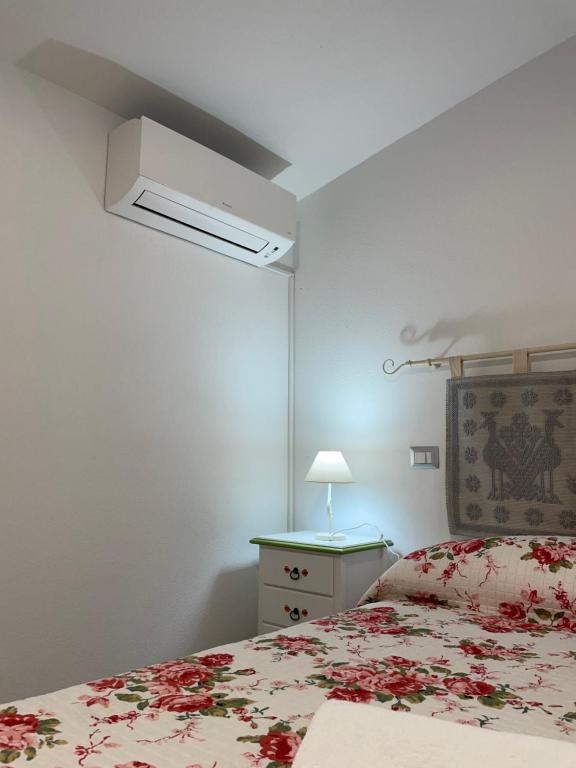1 dormitorio con 1 cama con colcha de flores en Affittacamere Il Vicoletto Aria Ona, en Villagrande Strisaili