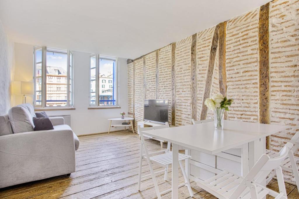 a living room with a white table and a couch at Flat with typical charm and terrace - Bayonne - Welkeys in Bayonne