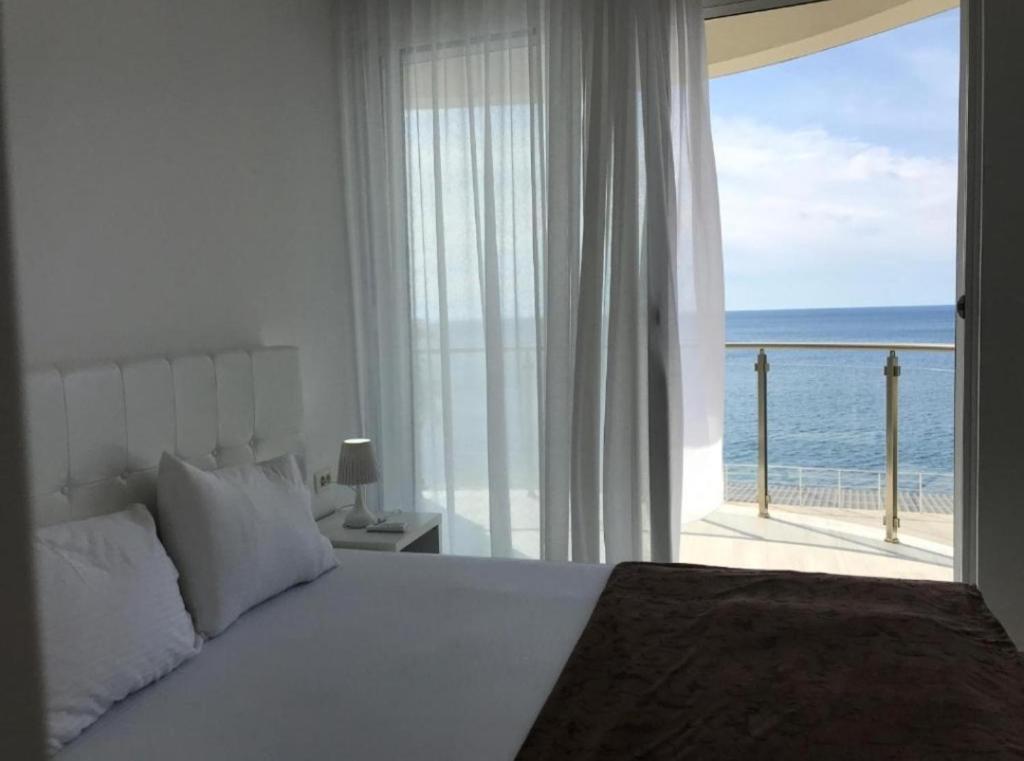 a bedroom with a bed and a view of the ocean at Paradise beachfront view 2 in Dobra Voda