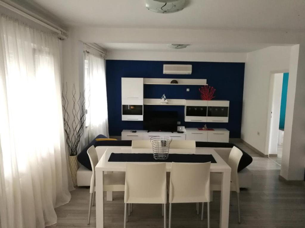 ein Esszimmer mit einem weißen Tisch und Stühlen in der Unterkunft Apartment Bilic in Fažana