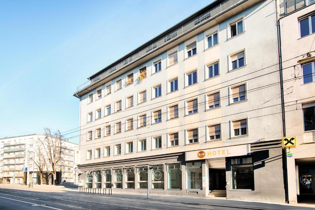 ein großes weißes Gebäude in einer Stadtstraße in der Unterkunft B&B Hotel Graz-Hbf in Graz