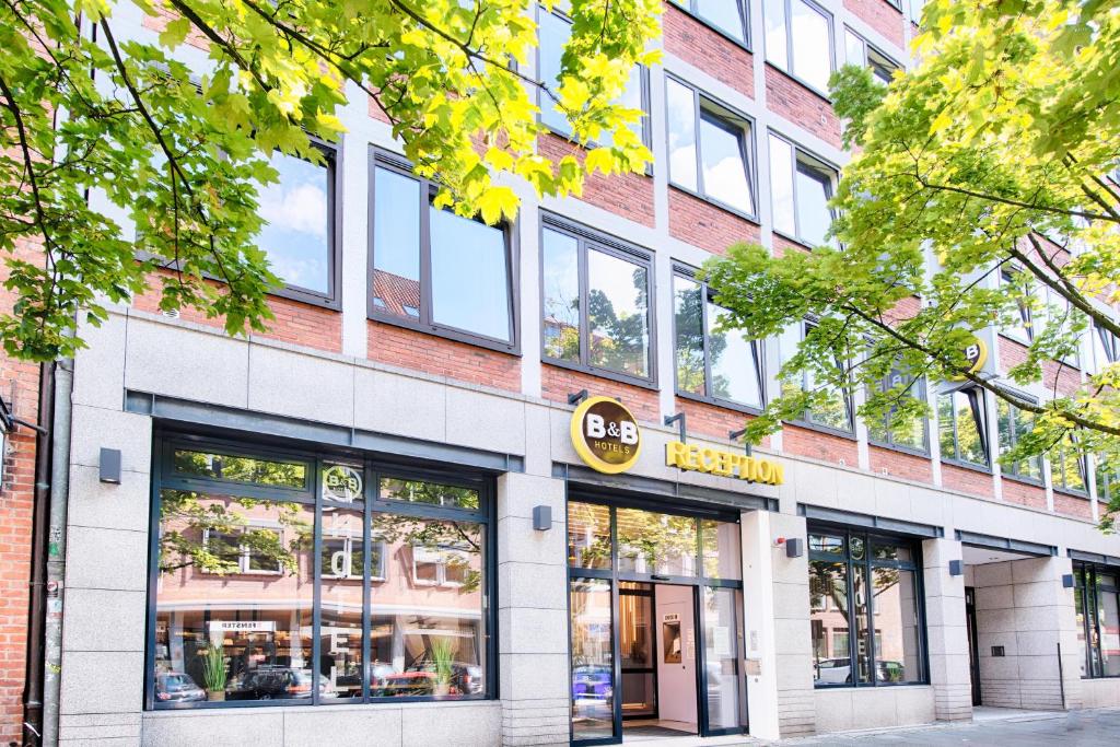 een winkel voor een bakstenen gebouw met ramen bij B&B Hotel Kiel-Holstenbrücke in Kiel