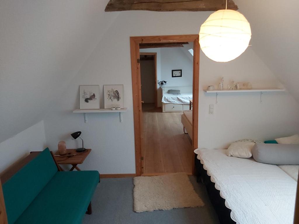 una pequeña sala de estar con sofá y cama en Bølshavnvej5 Bed & Breakfast, en Svaneke