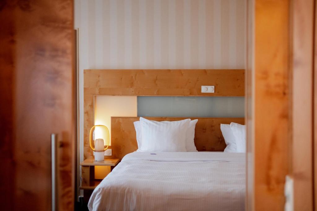 sypialnia z łóżkiem z białą pościelą i poduszkami w obiekcie stays by friends Gelsenkirchen w mieście Gelsenkirchen