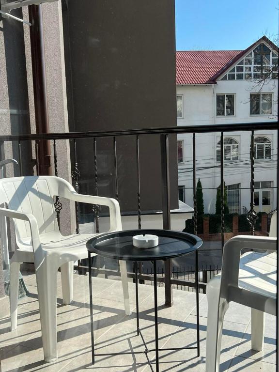 奇西瑙的住宿－Downtown Accommodation，阳台配有两把椅子和一张桌子